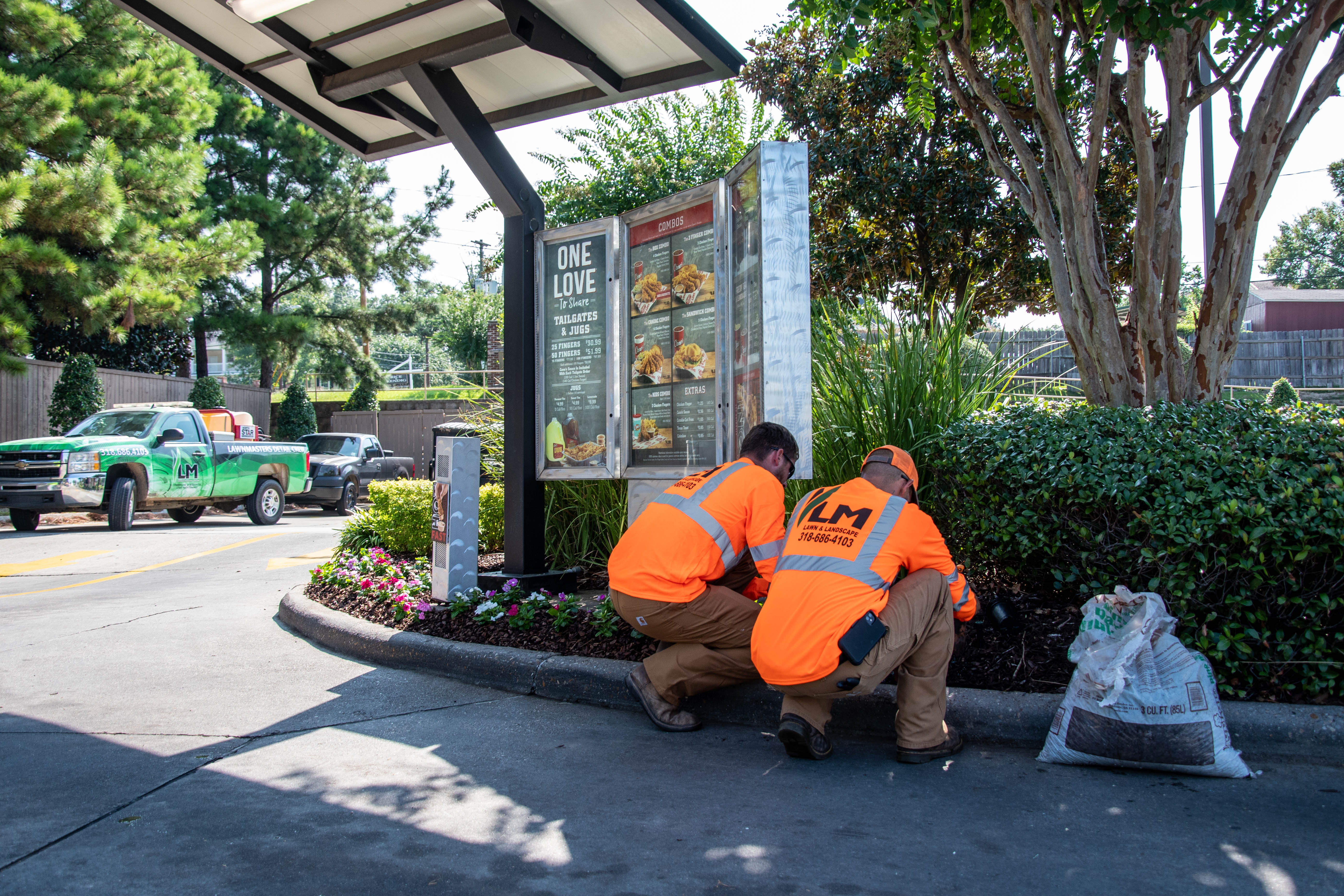 Lawnmasters team doing lawn care in front of restaurant
